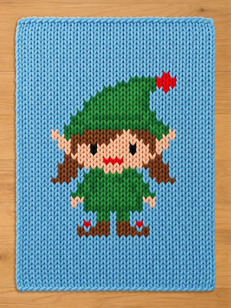 A rectangular light blue knit blanket featuring a central graphic of an elf. The elf has brown hair, a green hat with a red star, a green tunic, and brown shoes with red accents. The knit texture is consistent across the entire surface.