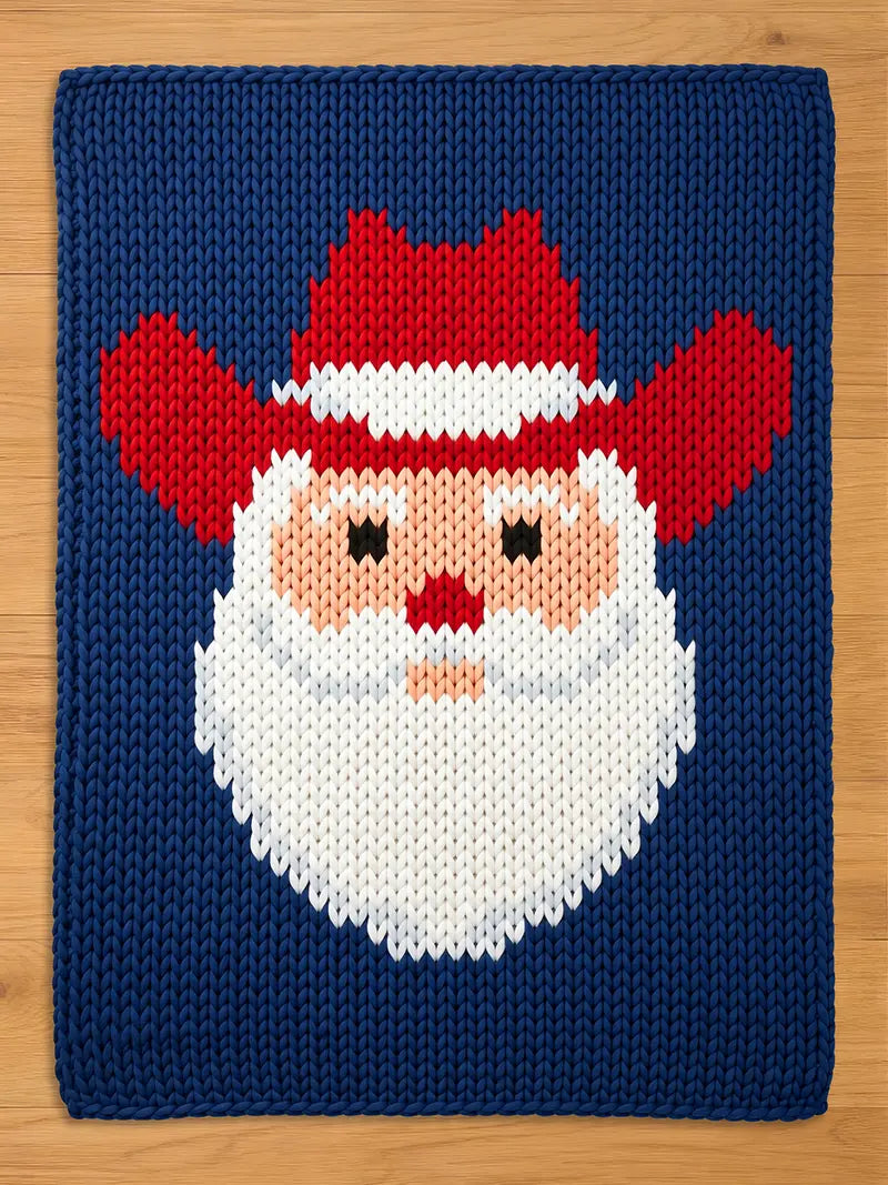 A knitted Christmas-themed square featuring a Santa Claus face. The design includes a red hat and beard, a peach-colored face, and a navy blue background. The Santa face is centered on the square.
