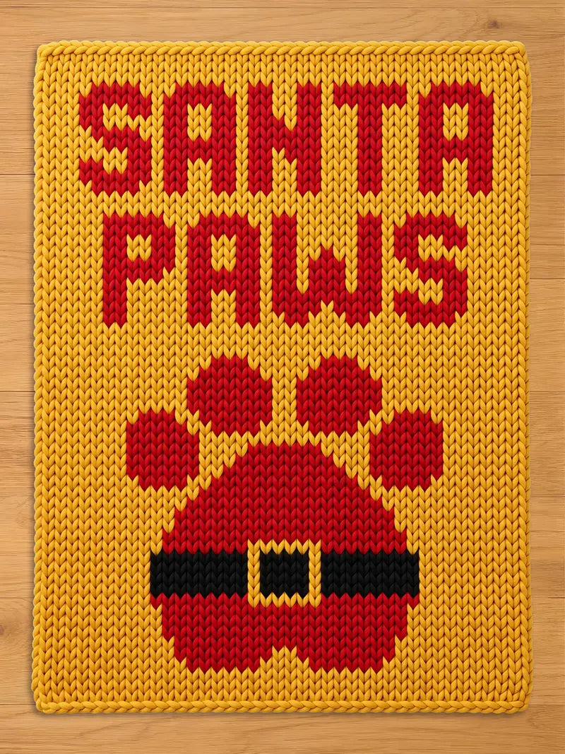 A rectangular yellow knit blanket featuring the red text SANTA PAWS at the top. Below the text is a large red paw print graphic with a black belt and a yellow buckle design integrated into the center of the paw pad.