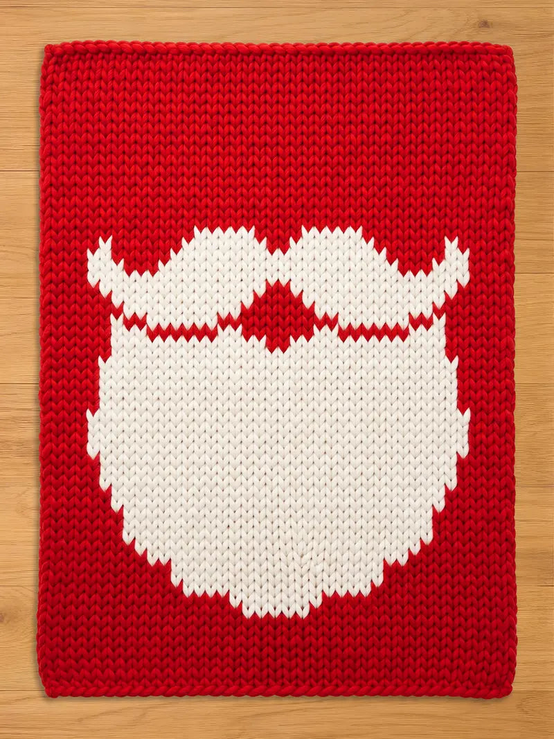 A rectangular knitted chunky blanket featuring a vibrant red background with a large, centered white graphic depicting a stylized mustache and beard. The knit pattern is uniform and chunky, creating a textured surface across the entire piece.