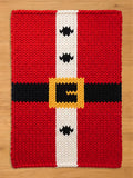 A rectangular knitted textile featuring a red background with a vertical white stripe down the center. The design includes a horizontal black band across the middle with a yellow square buckle and three small black diamond shapes.