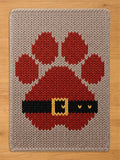 Chunky knit beige blanket featuring a large red paw print designed to look like a Santa suit with a black belt and yellow buckle.